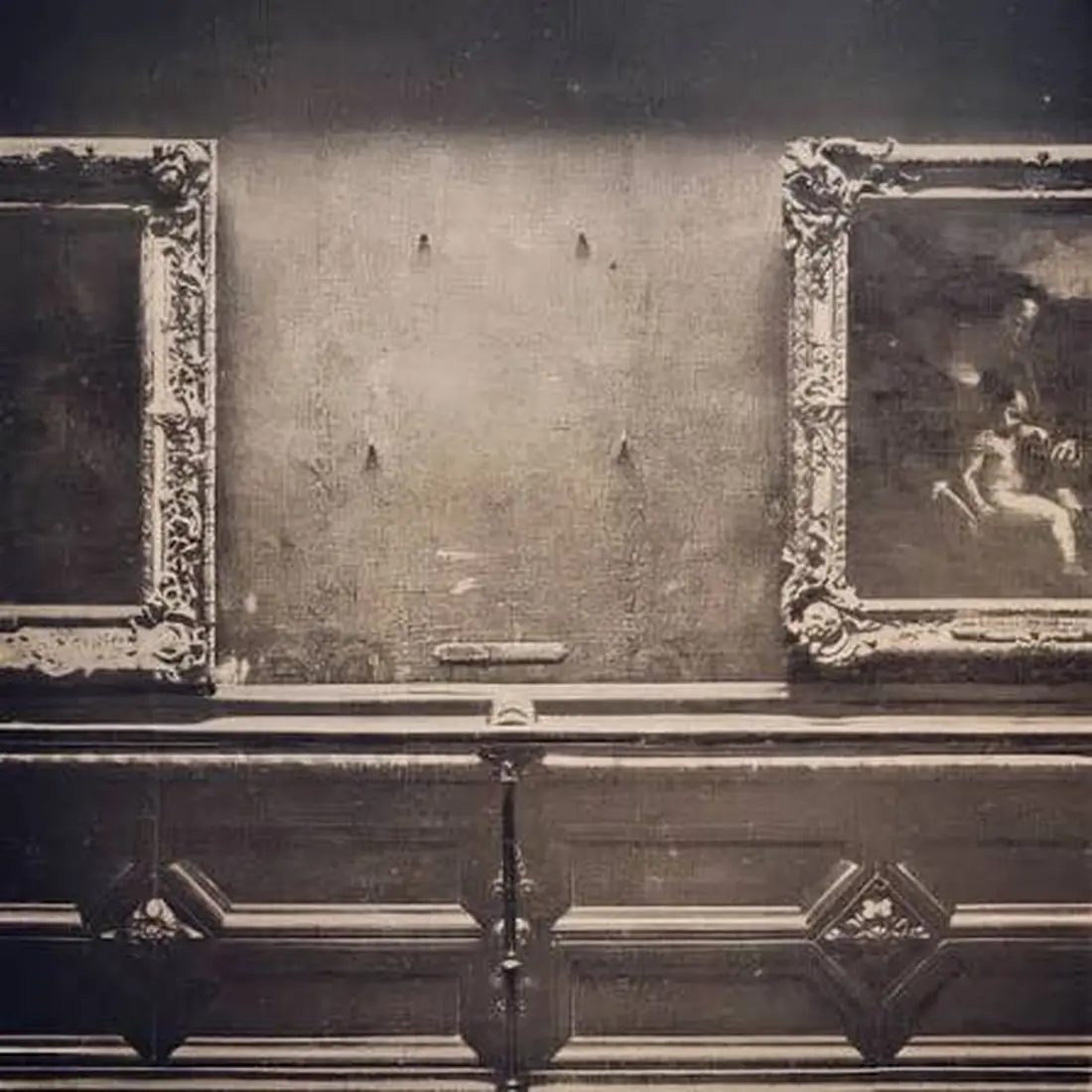 The empty wall in the Salon Carré after the Mona Lisa was stolen in 1911, four bare hooks between two framed paintings