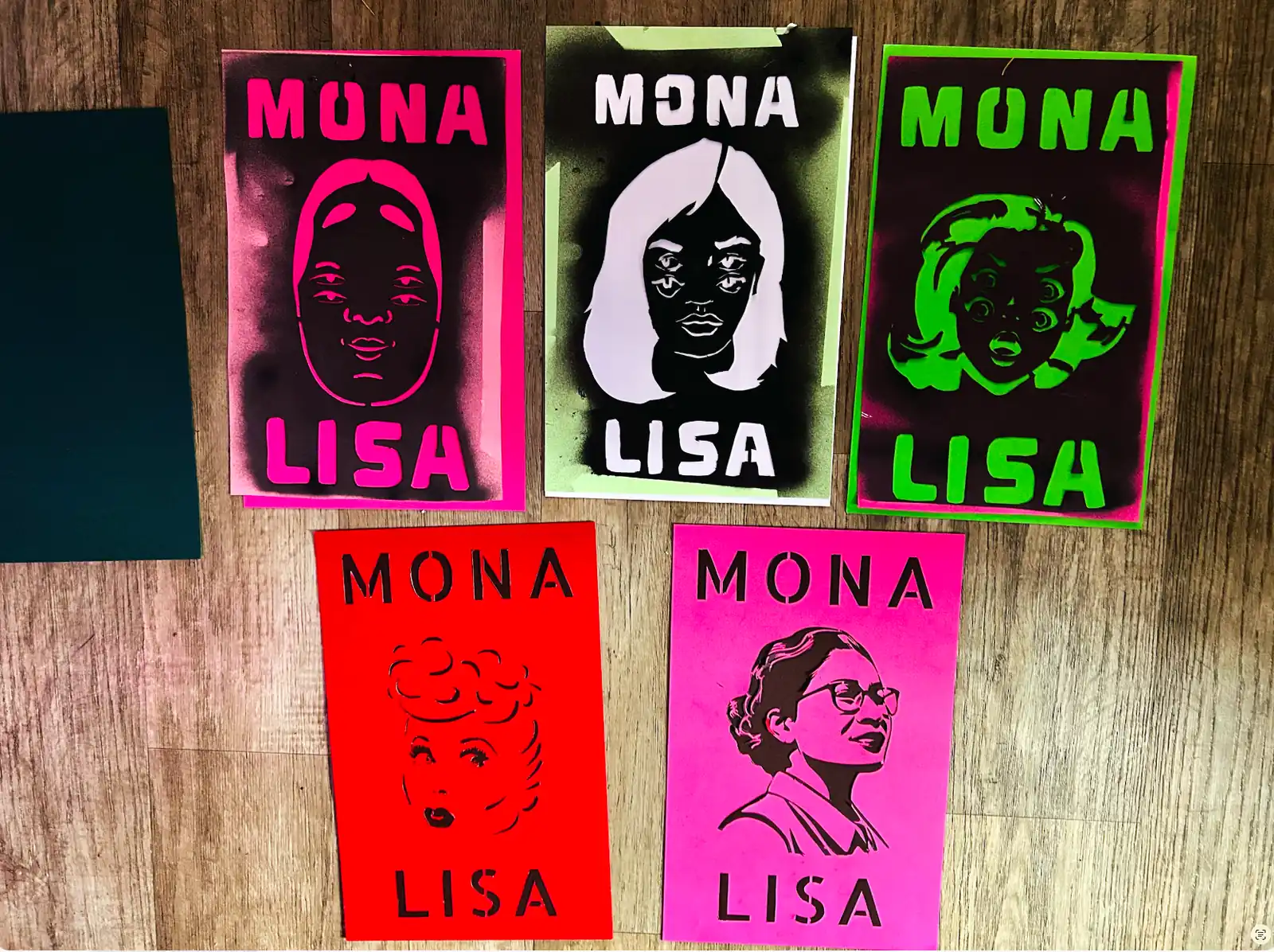 Five Mona Lisa stencils on a wood floor in pink, green, red, black and white: five different women, none of them the Louvre’s